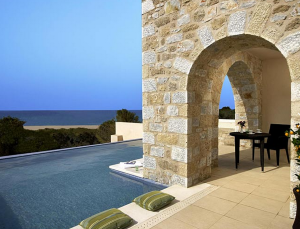 a pool with a stone wall and a stone arch