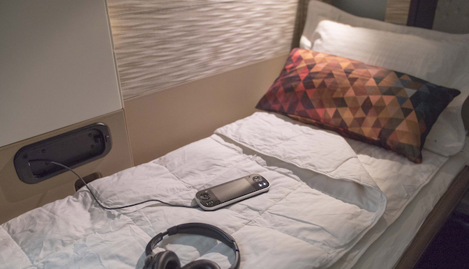 a bed with headphones and a phone on it