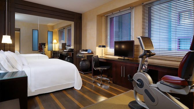 a room with a bed and exercise bikes