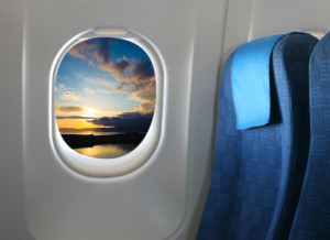 a window of an airplane with a seat belt and a sunset