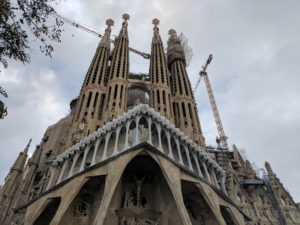 a large building with towers and a roof with Sagrada Família in the background