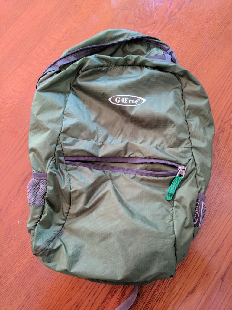 a green backpack on a wood surface