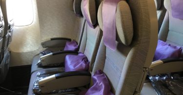a row of seats with purple pillows