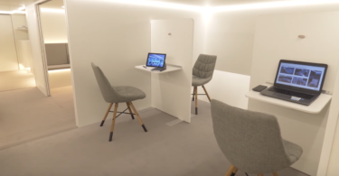 a room with a laptop and chairs