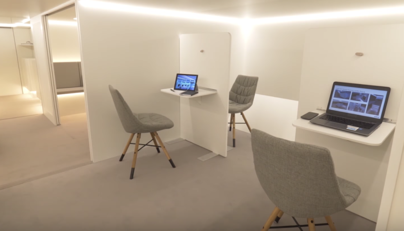 a room with a laptop and chairs