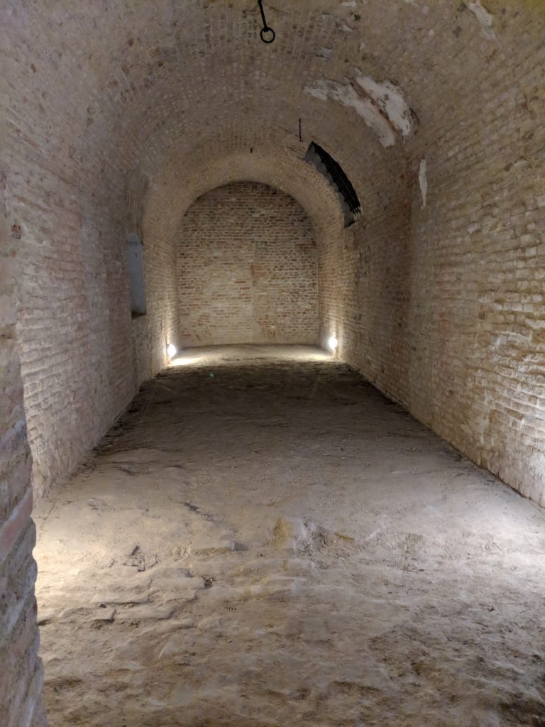 a brick tunnel with arched ceiling and light