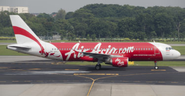 a red and white airplane on a runway