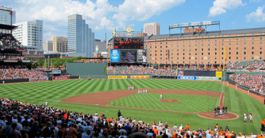 a baseball game in a stadium with Oriole Park at Camden Yards in the background