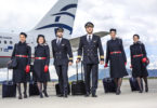 a group of people in uniform with luggage