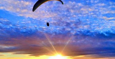 a person flying a parachute in the sky