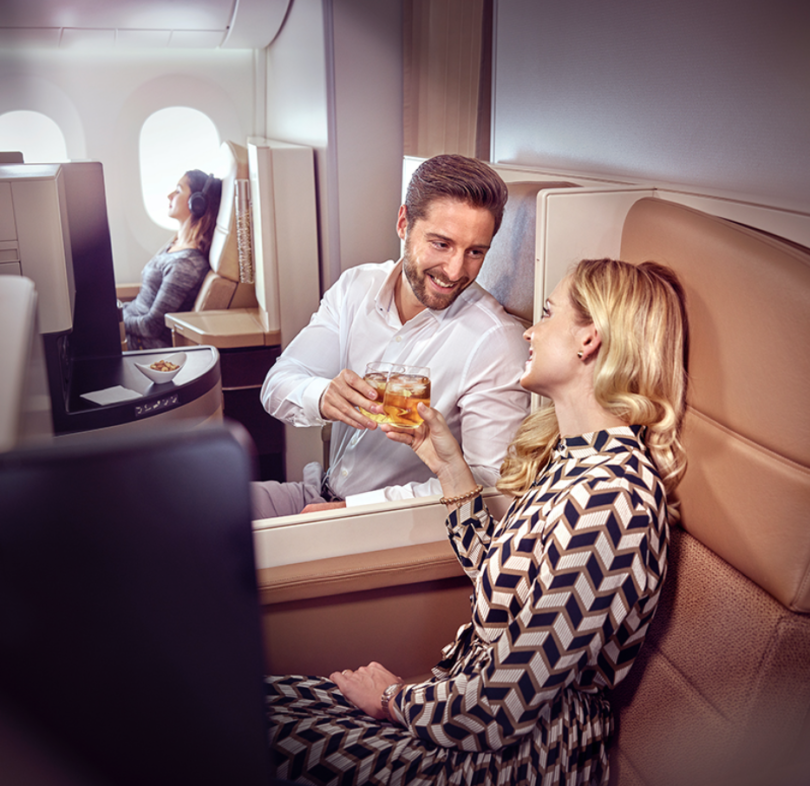 a man and woman sitting in a chair on an airplane