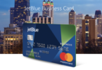 a blue and green credit card with city skyline in the background