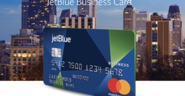 a blue and green credit card with city skyline in the background