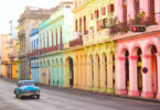 a car driving down a street with colorful buildings