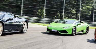 a green sports car and a black car on a road