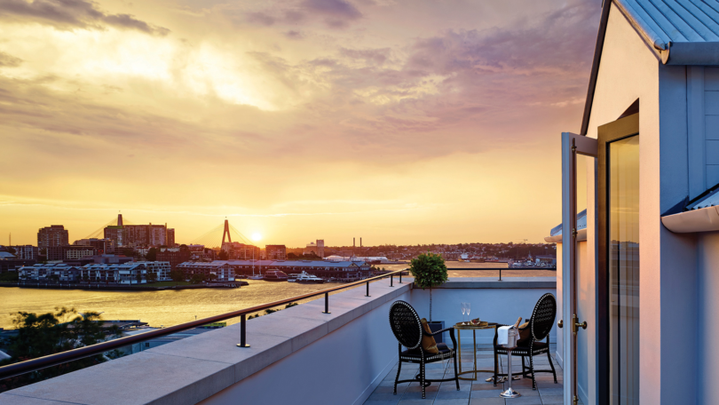 a table and chairs on a rooftop overlooking a city