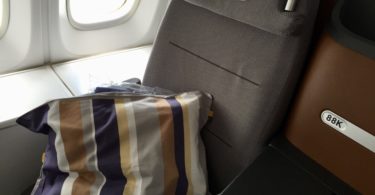 a seat with a striped pillow on the side of it