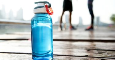 a blue water bottle on a wooden surface