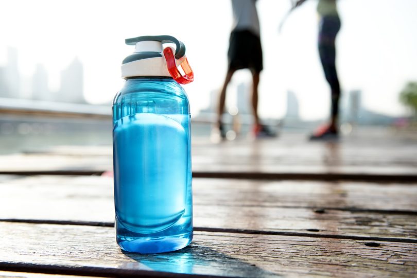 a blue water bottle on a wooden surface