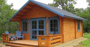 a small log cabin with blue trim