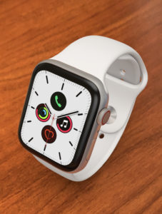 a white smart watch on a wood surface