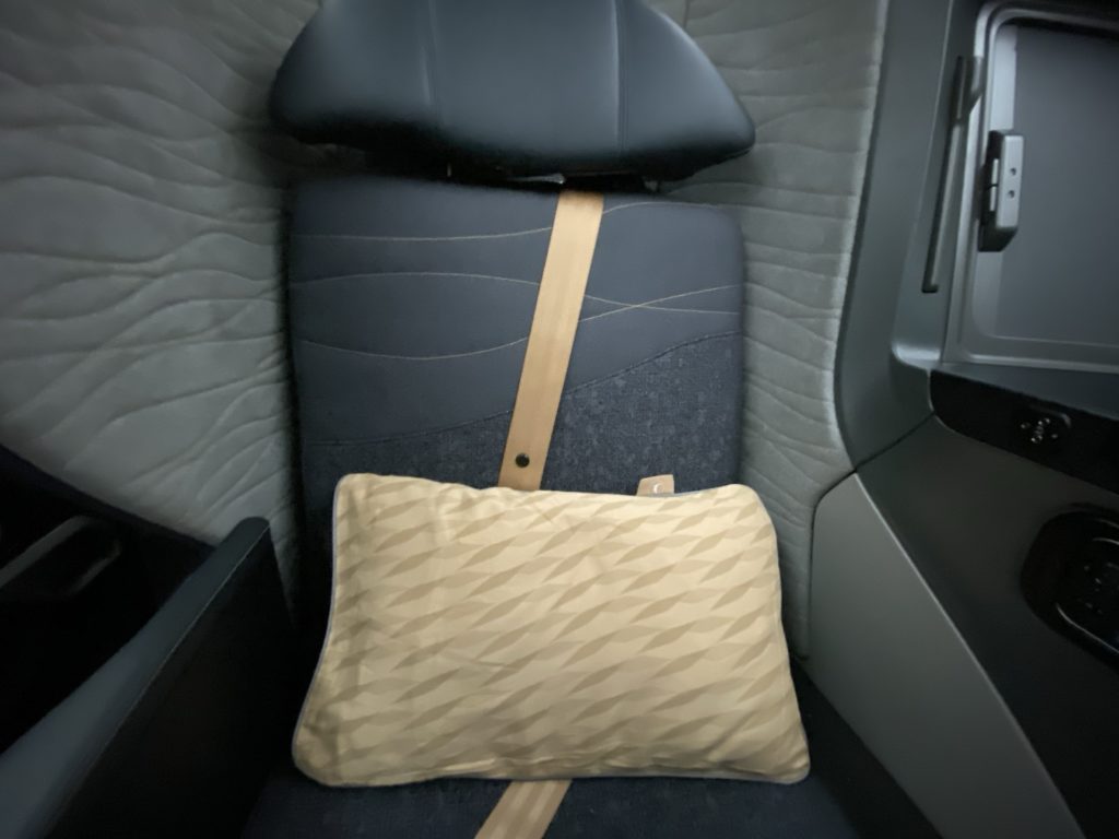 a seat with a pillow and a headrest in a car