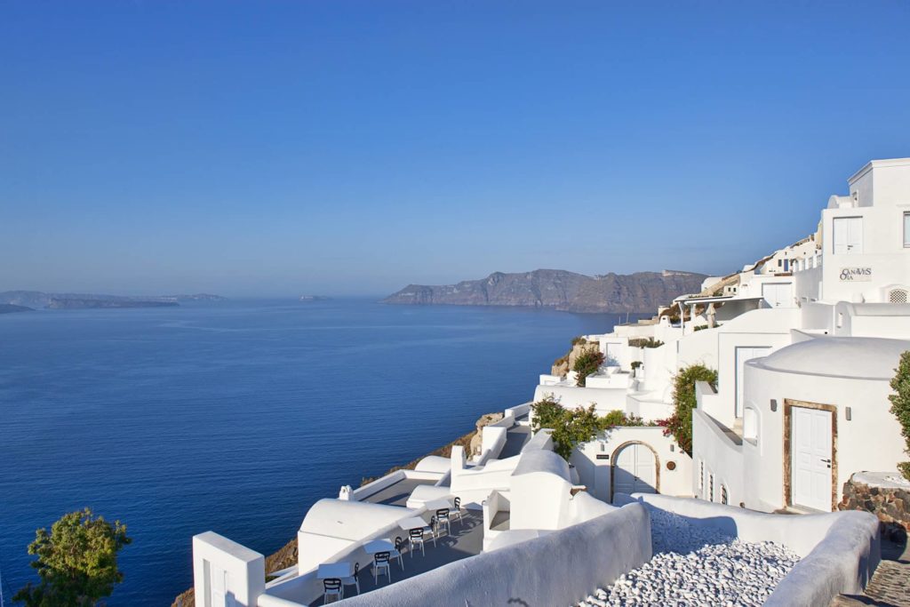 a white buildings on a cliff overlooking the ocean