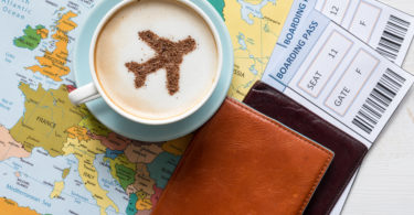 a cup of coffee with a plane design on top of a map
