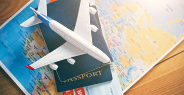 a toy airplane on top of a passport and a map