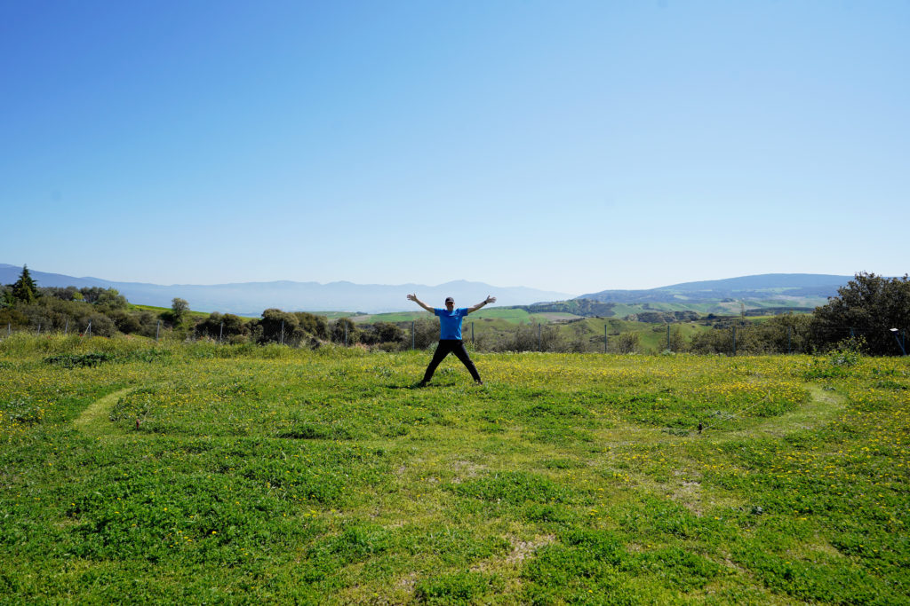 a man standing in a field with his arms outstretched