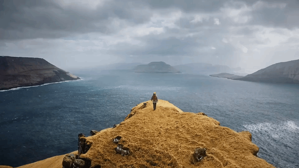 a person standing on a cliff overlooking water