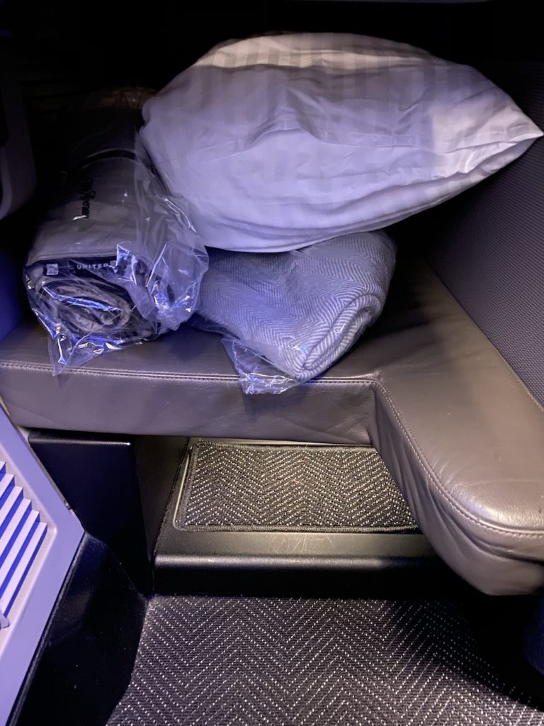 a seat with a pillow and a blanket