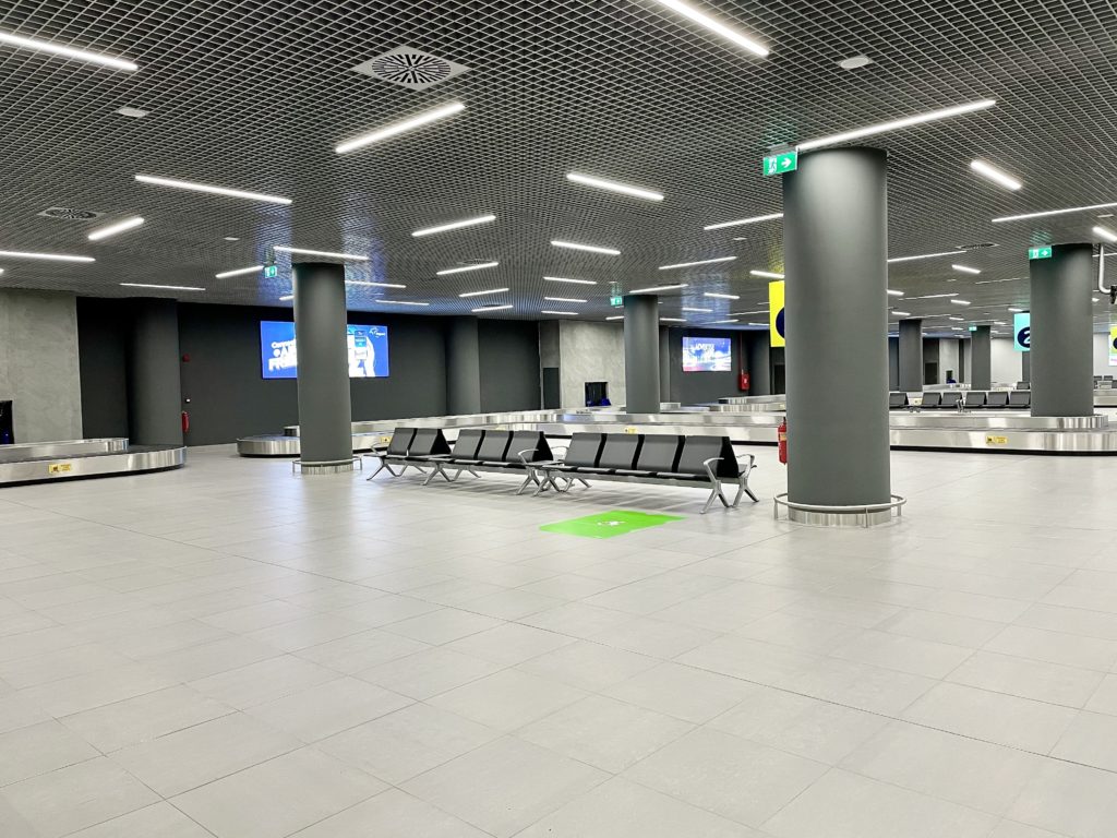 a large airport terminal with benches and columns