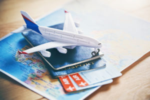 a toy airplane on top of a passport and tickets