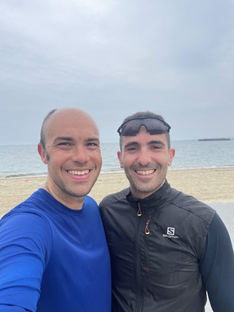 two men taking a selfie on a beach