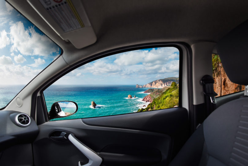 a car with a view of the ocean and mountains