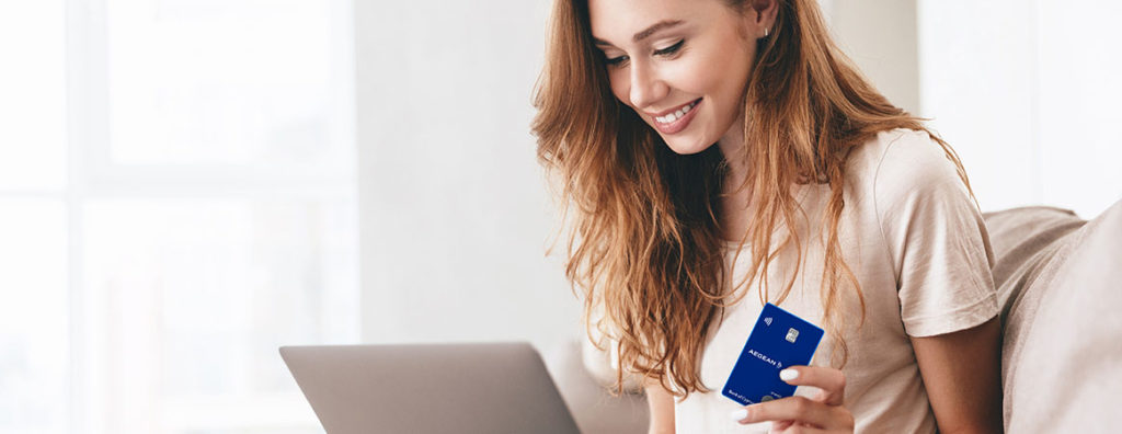 a woman holding a credit card and a laptop