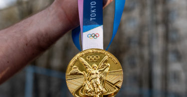a person holding a gold medal