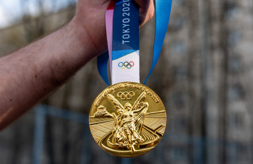 a person holding a gold medal