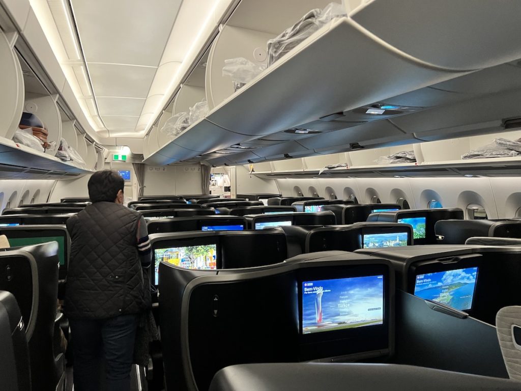 a person standing in an airplane with rows of monitors