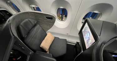 an airplane seat with windows and a screen