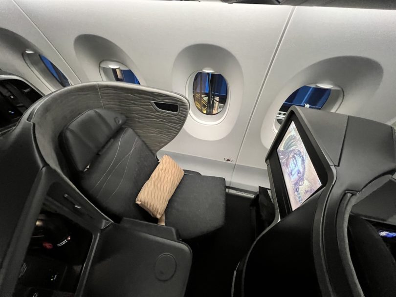 an airplane seat with windows and a screen