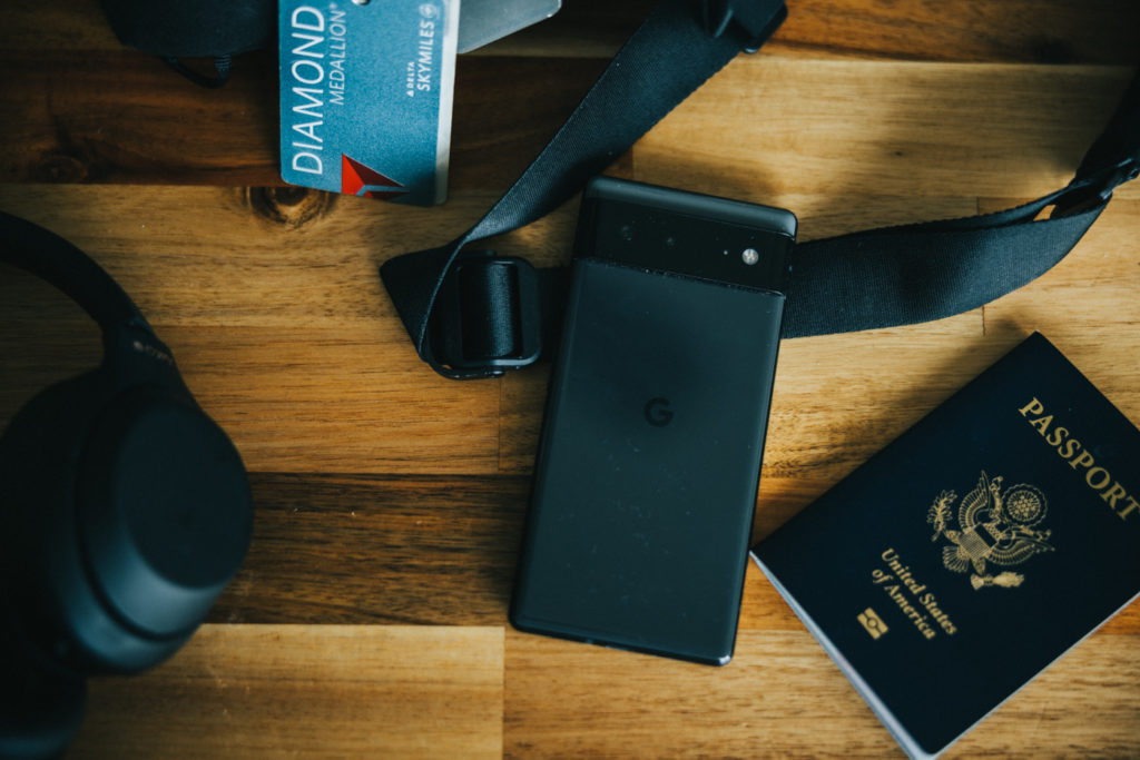 a black device next to a passport and a camera