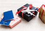 a gift box with a toy airplane and a red ribbon on it