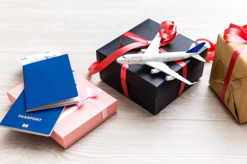 a gift box with a toy airplane and a red ribbon on it