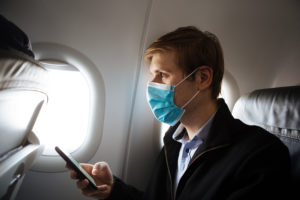 a man wearing a face mask while using a phone