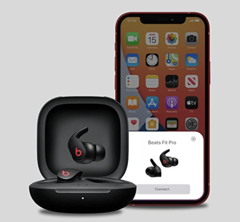 a black wireless earbuds in a case next to a cellphone