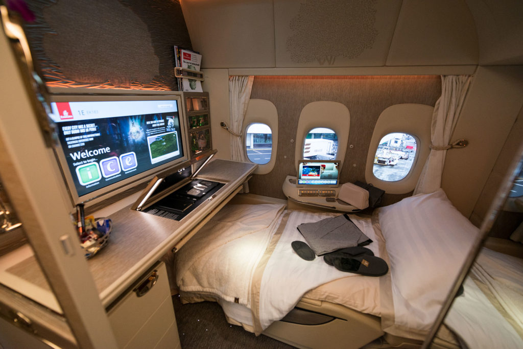 a bed with a computer and a desk in a plane