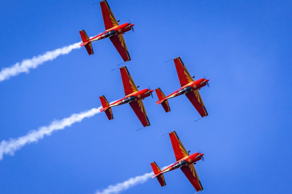 a group of red airplanes flying in the sky