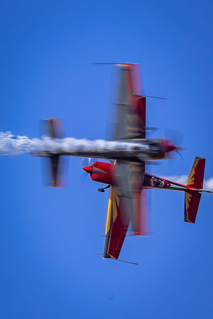 a red and yellow airplane with smoke coming out of it